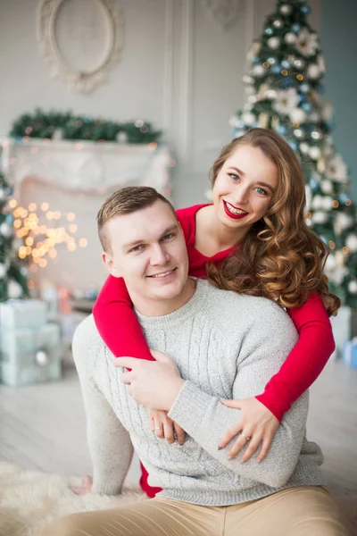 Happy mladí lidé dávají navzájem dárky krbu u vánočního stromu. Nový rok koncepce. — Stock fotografie