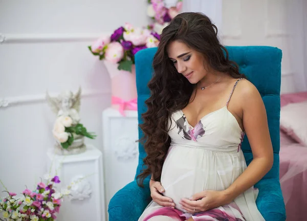 Portret van de jonge zwangere mooie brunette met krullend haar in — Stockfoto