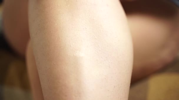 Chica afeita el pelo en su pierna con una depiladora — Vídeo de stock