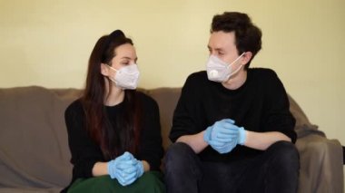 Maskeli adam ve lastik eldivenler kanepede oynaşıyor.