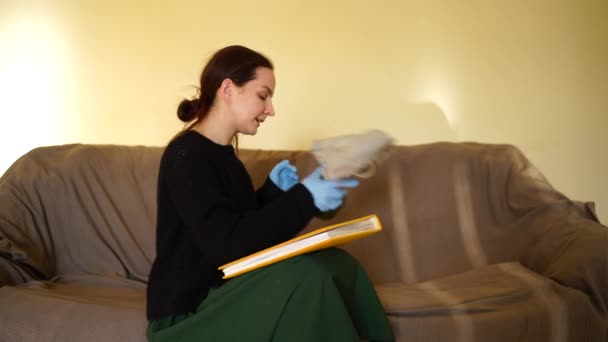 Белая женщина снимает противогаз и листает книгу со смехом — стоковое видео