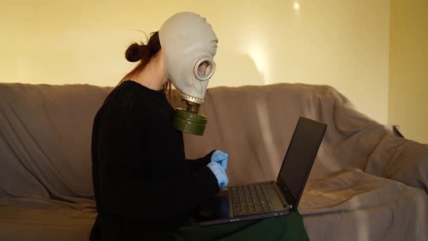 Ragazza bianca in maschera antigas funziona da casa su un computer — Video Stock