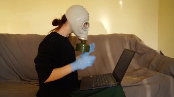 Жінка знімає газову маску і друкує на клавіатурі комп'ютера — стокове відео