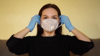 Beyaz kadın yüzüne kumaş bir maske takıyor.