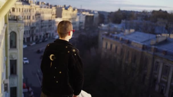 Meisje met geschoren hoofd staat op het balkon van het huis — Stockvideo