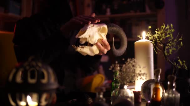 Kouzelník v havraní masce hladí kozí lebku za svitu svíčky — Stock video