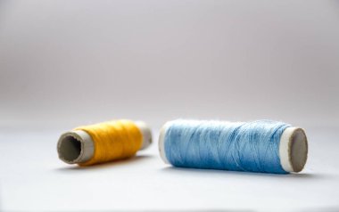 Beyaz arkaplanda mavi ve sarı iplik.