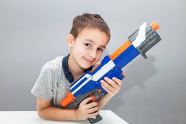 Küçük çocuk oyuncak silah tutan