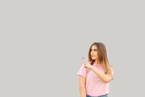 Молодая Позитивная Девушка Указывает Пальцем Влево Одета Розовую Футболку Изолированный — стоковое фото