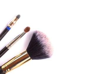 Beyaz arka planda üç makyaj fırçası