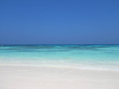                                Açık mavi gökyüzü ve deniz, kumsalda beyaz kumlar