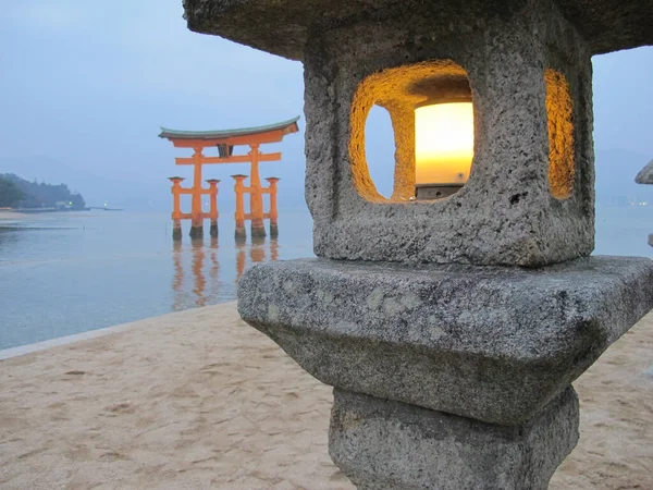 Sırtında büyük bir torii olan taş lambalar.