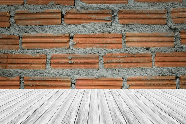 Поверхность стены из красного кирпича с террасой из дерева — стоковое фото