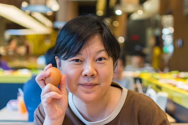 Mujer de Asia sosteniendo un huevo en la barbacoa. yakiniku parrilla restaurante buffet — Foto de Stock