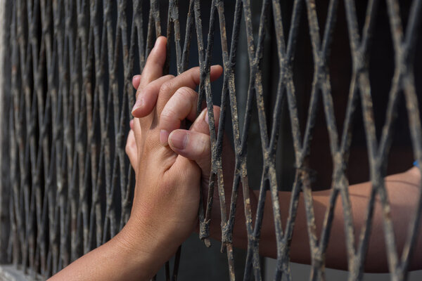 Hands of the man and woman on a steel lattice