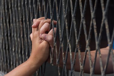 Eller erkek ve kadın üzerinde çelik kafes yakın çekim