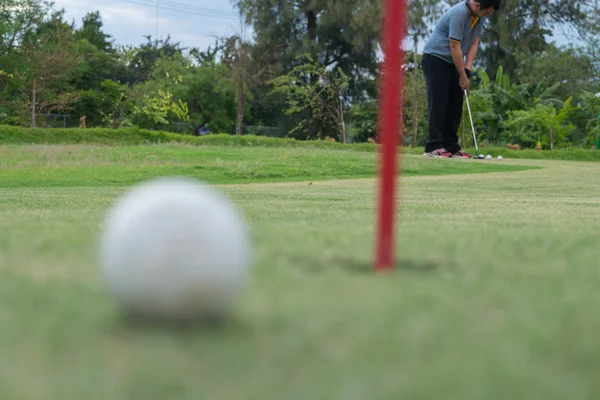 Jugador de golf y bola de golf labio del agujero en verde — Foto de Stock