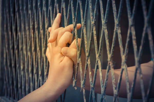 Hands of the man and woman on a steel lattice