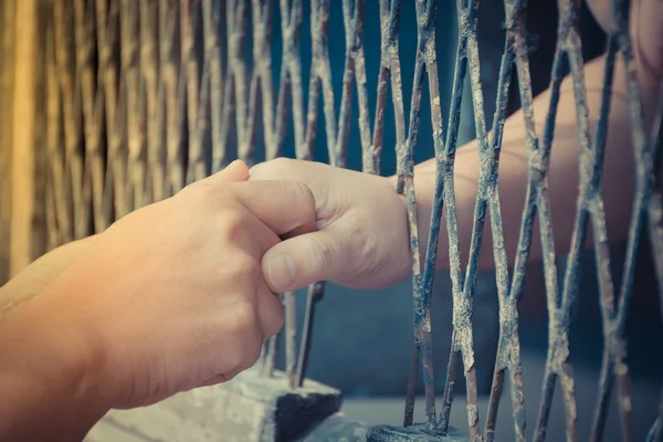 Eller erkek ve kadın üzerinde çelik kafes — Stok fotoğraf