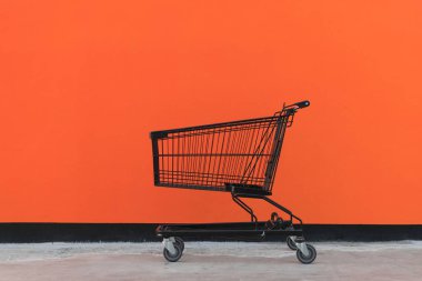 Minimalizm tarzı, alışveriş sepeti ve turuncu duvar.