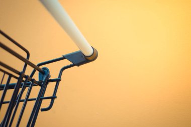 Minimalizm tarzı, alışveriş sepeti ve sarı duvar.