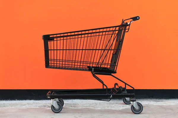 Minimalisme stijl, Shopping cart en oranje muur. — Stockfoto