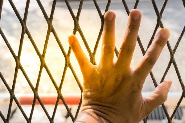 Руки человека на стальной решетке вблизи — стоковое фото