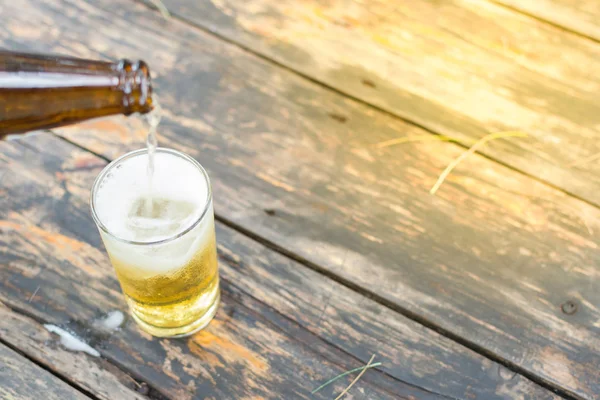 Beer pouring with ice in glass