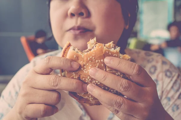 Азиатка ест гамбургер — стоковое фото