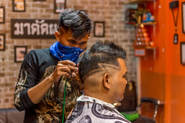Peluquería corte de pelo a un cliente en la barbería —  Fotos de Stock