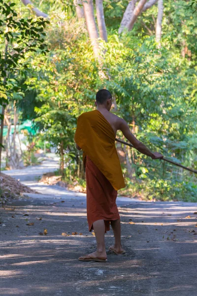 Thailändischer Mönch fegt einen Tempelboden — Stockfoto