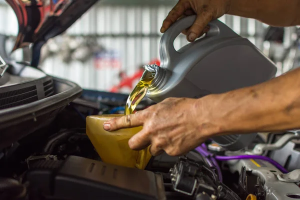 Mécanicien de voiture remplit une huile moteur lubrifiant frais — Photo