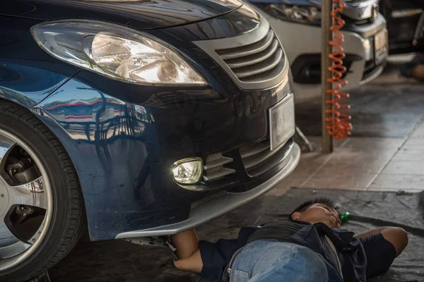 Verificar um farol do carro para reparação na garagem do carro — Fotografia de Stock