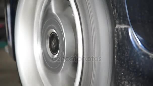 Girar las ruedas de un coche para comprobar la suspensión del coche — Vídeo de stock