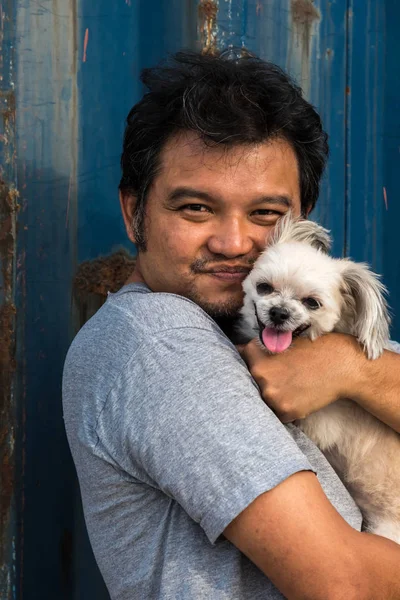 Asia man and dog happy hugging with container