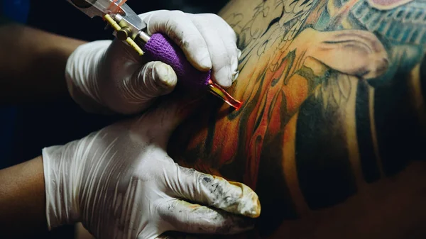 Tattoo artist drawing art on body — Stock Photo, Image