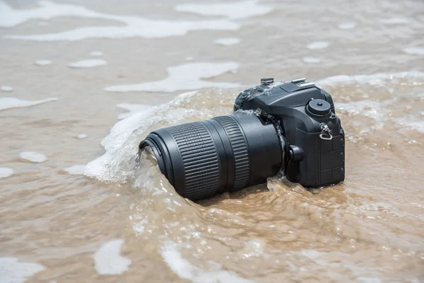 Camera on a beach it wet from sea wave — Stock Photo, Image