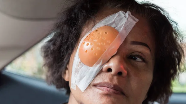 Patient asian women show her eyes with eye shield — Stock Photo, Image
