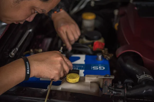 Verificação de uma bateria de carro para reparação na garagem do carro — Fotografia de Stock