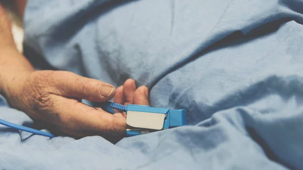 Paciente en el hospital con pulsiómetro en el dedo — Foto de Stock