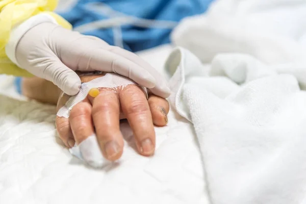 Patient in the hospital and holding a hand