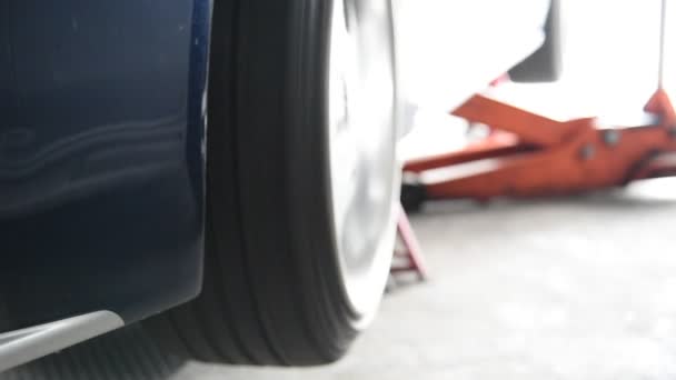 Girar las ruedas de un coche para comprobar la suspensión del coche — Vídeo de stock