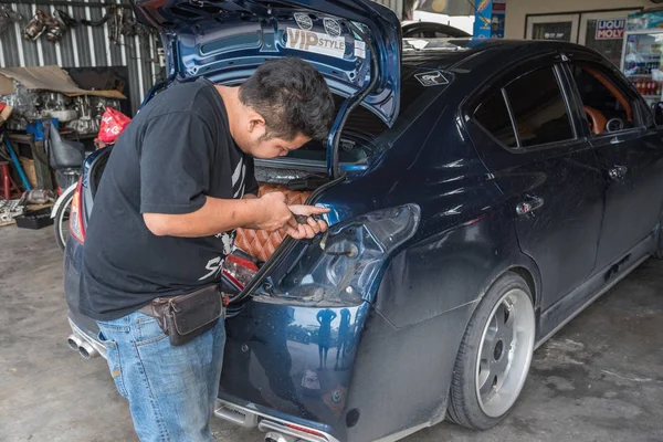Verificar um farol traseiro do carro para reparação na garagem do carro — Fotografia de Stock