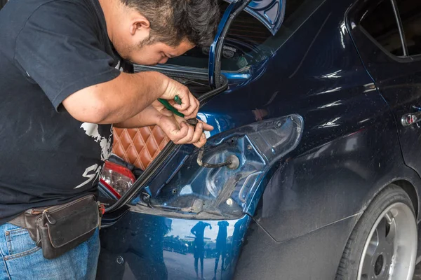 Comprobación de un coche luz trasera para la reparación en el garaje del coche — Foto de Stock