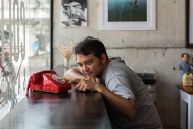 Bir kafede Asya adam utangaç bekleyen telefon görüşmesi