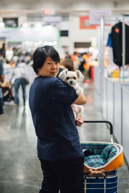 Asyalı kadın ve köpek sergi salonuna veya expo