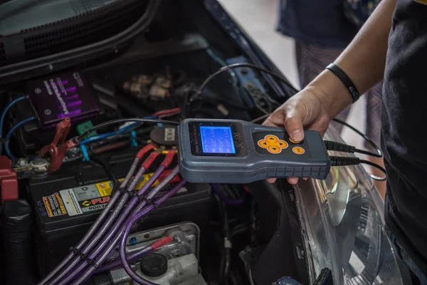 Verificação de uma bateria de carro para reparação na garagem do carro — Fotografia de Stock