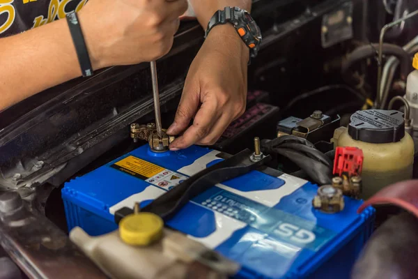Verificação de uma bateria de carro para reparação na garagem do carro — Fotografia de Stock