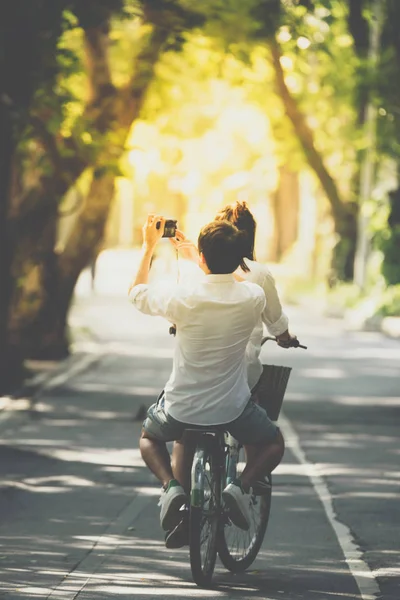 Para na rowerze rower używać aparatu w parku — Zdjęcie stockowe