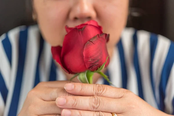 Mujer oliendo flor de rosa roja en San Valentín —  Fotos de Stock